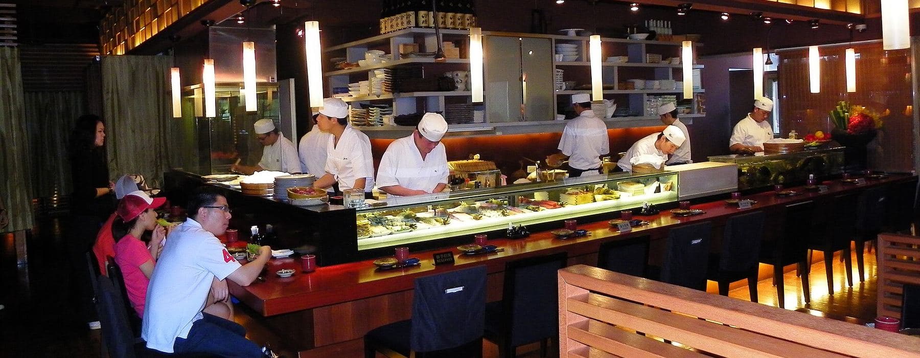 Sushi tezgâhında çalışan aşçılar